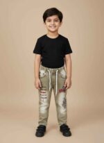 Close-up of Kids Boy Green Denim Jeans with stitch design and white drawstring detail.Full shot of Gelani Kids Boy Green Jeans on a neutral background. Detail view of the stitch and embroidered graphic on the left leg of the children's jeans. View of the back pockets and durable denim texture of the boy's green jeans .Kids boy's winter fashion denim jeans in green with elastic waist.