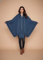 Pakistani model in a long, light grey diamond Quilted Cap Shawl, white top, and blue jeans, walking in a park with autumn leaves.