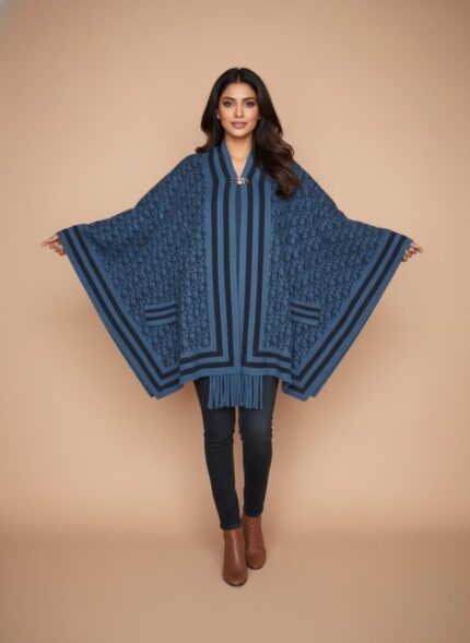 Pakistani model in a long, light grey diamond Quilted Cap Shawl, white top, and blue jeans, walking in a park with autumn leaves.