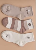 Set of three women's cute ankle socks in beige, white, and striped brown designs, each with a playful motif like a bear or a smiley face slogan.