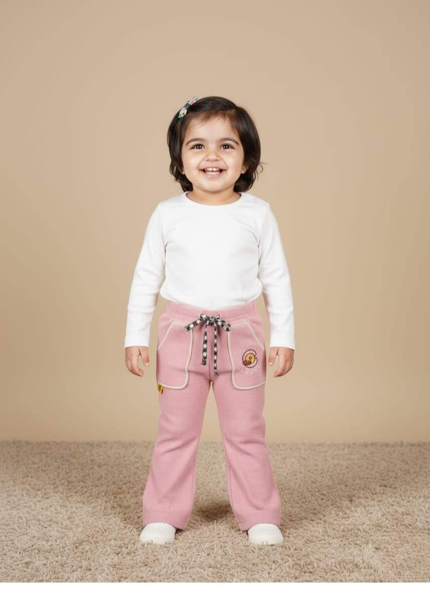 "Pair of light pink wide-leg girls' pink trouser made of corduroy fabric, showing an elasticated waist with a black and white checkered drawstring, large front patch pockets with cream trim, and an embroidered circular graphic on the right pocket."