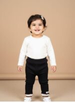 Folded pair of plain black stretch leggings for kids, featuring a smooth, design and an elastic waistband.