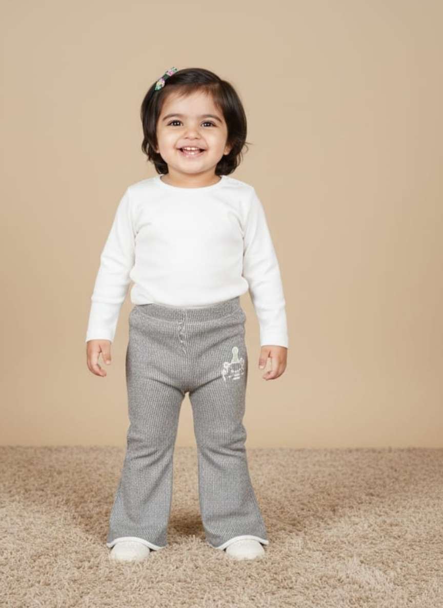 Flat lay view of brown ribbed knit baby pants with a small white animal graphic on the lower right leg and cuffed ankles.