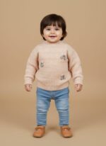 Light pink knitted sweater with a subtle checkered pattern, speckled yarn, mock neck, and three decorative white and mint-green floral appliqués on the chest.