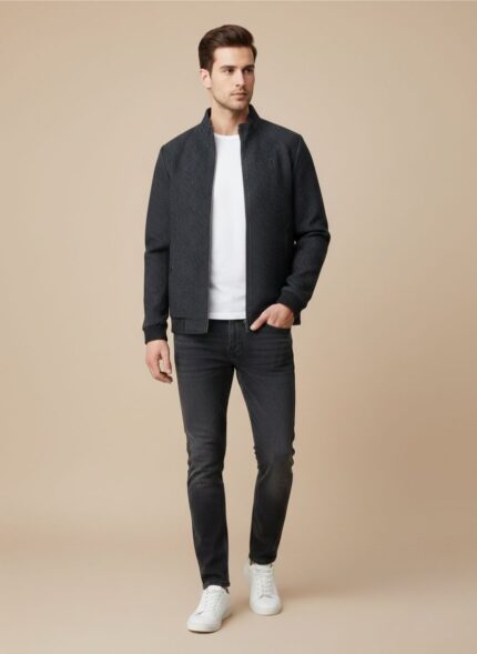 Full view of a new Men's Black Bomber Jacket displayed flat on a blue surface, showing the ribbed stand collar, full zipper, black ribbed cuffs and hem, and the all-over subtle patterned fabric with two zippered front pockets.